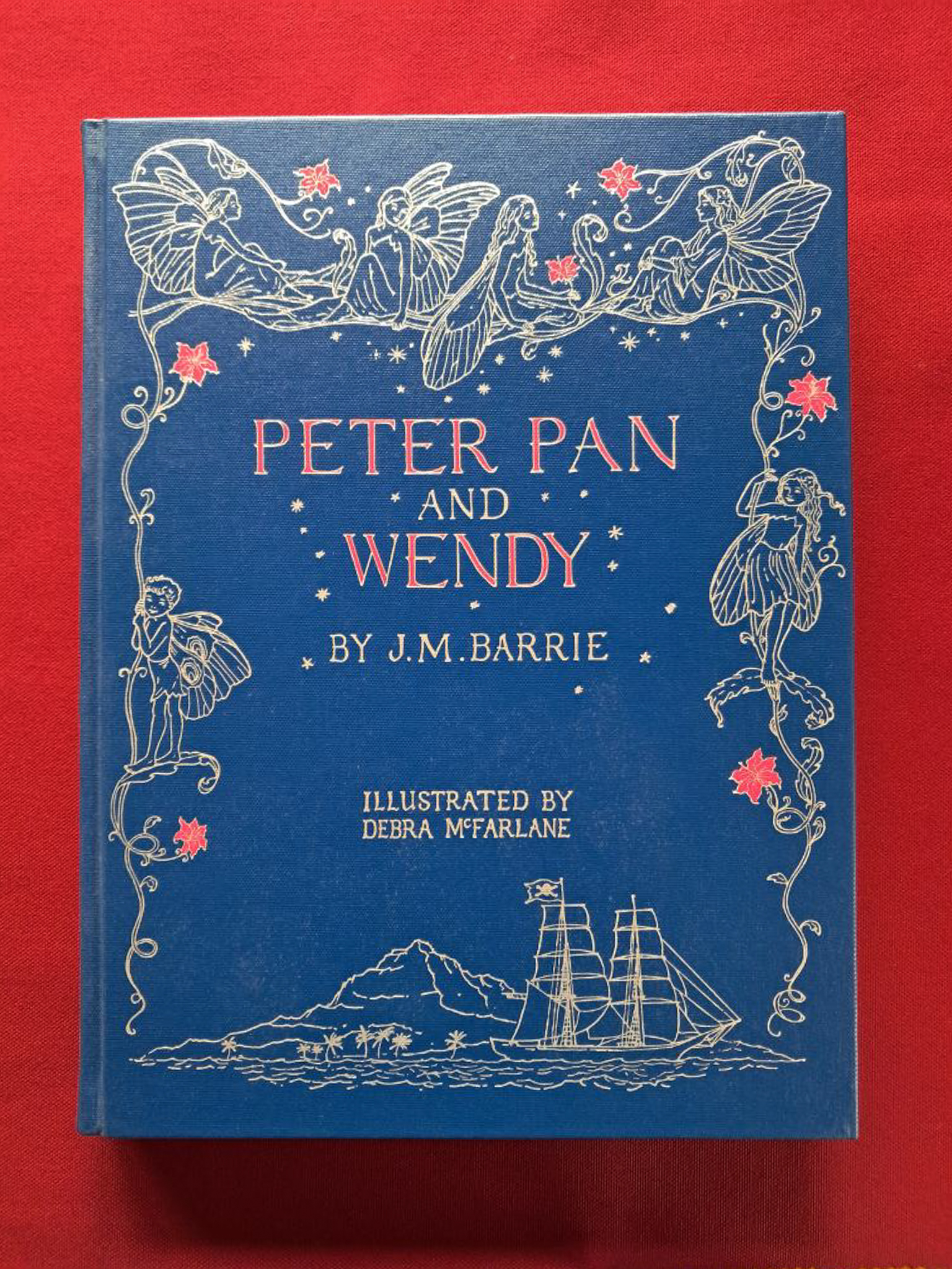 Peter Pan and Wendy. A dark blue cover on a dark red background