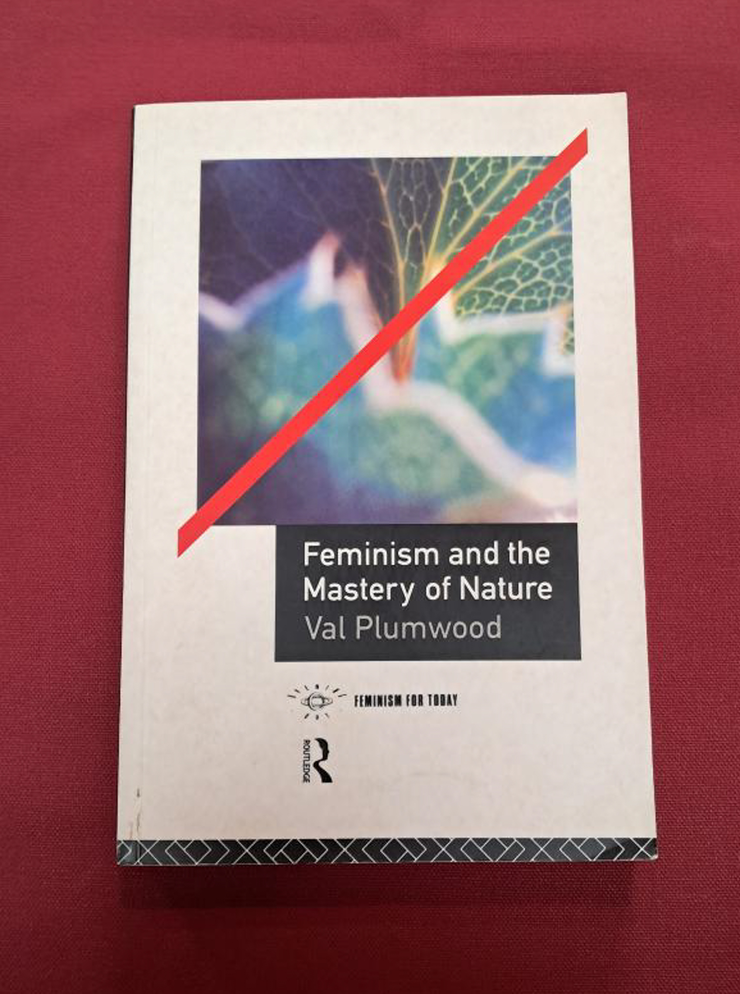 Feminism and the mastery of nature. Of white cover with close up image of a leaf with a thick red line through it