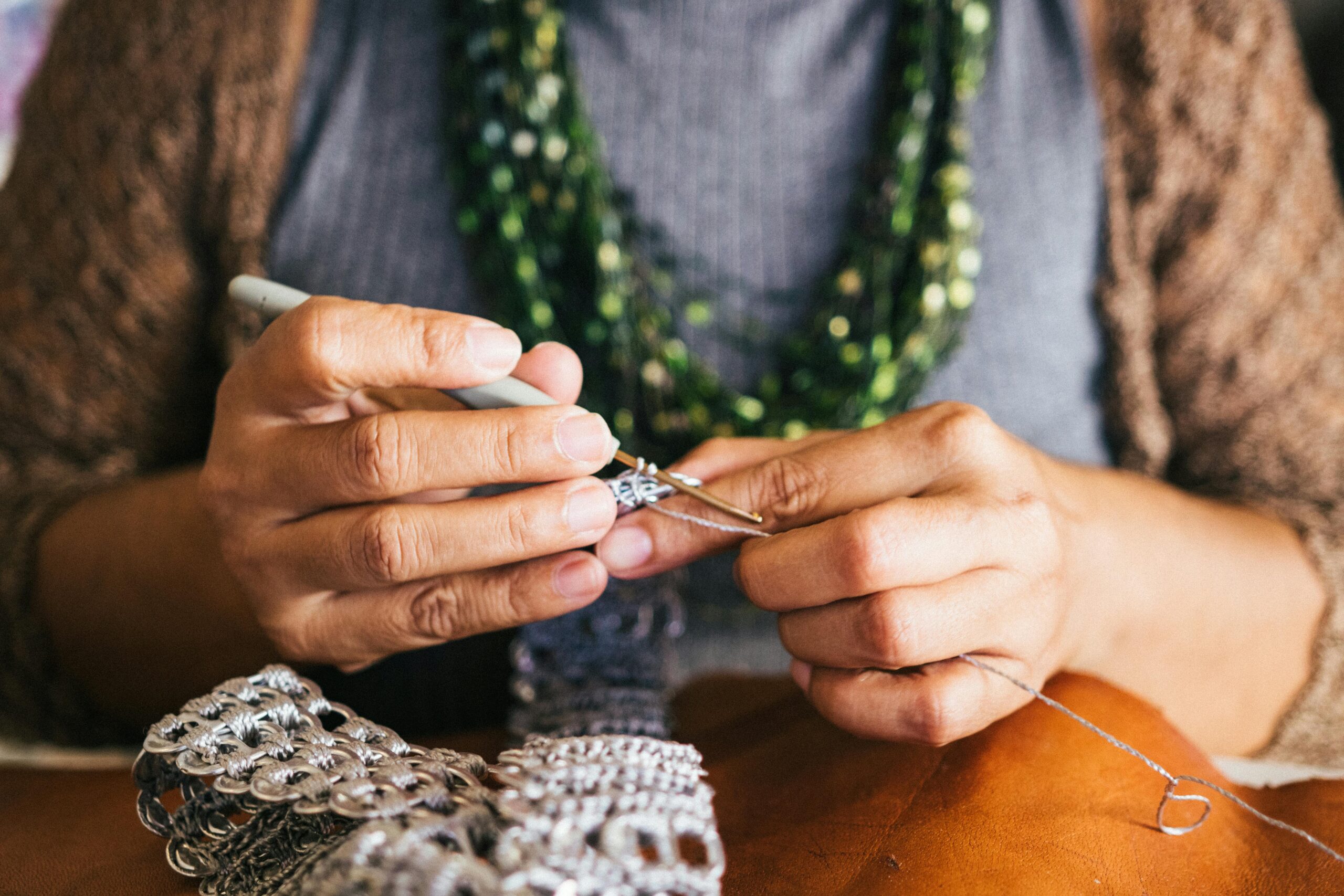 A close up of a person's hands crocheting